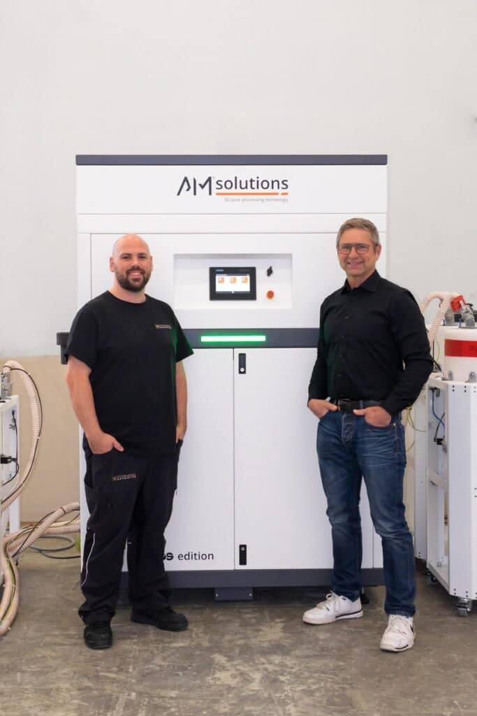 Post-Processing at Formnext 2025: Unpacking, Depowdering, Resin Removal, & More3DPrint.com | Additive Manufacturing Business 2 IMG Peter Spitzwieser right in front of the F1 683x1024